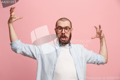 Image of Portrait of an angry man looking at camera isolated on a pink background