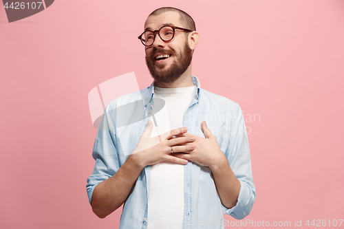 Image of The happy business man standing and smiling against pastel background.