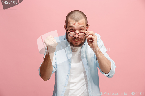 Image of Portrait of an angry man looking at camera isolated on a pink background