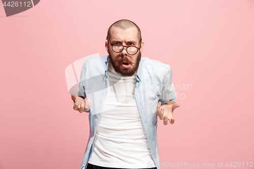 Image of Portrait of an angry man looking at camera isolated on a pink background