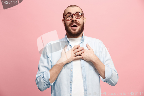 Image of The happy business man standing and smiling against pastel background.