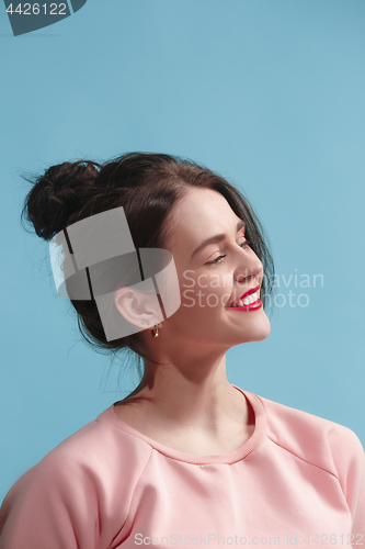 Image of The happy business woman standing and smiling against blue background.