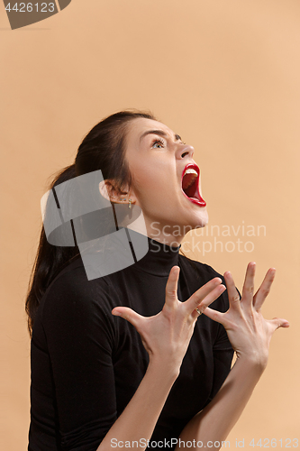 Image of The young emotional angry woman screaming on pastel studio background