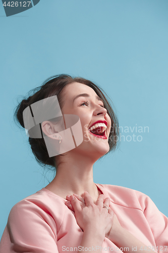 Image of The happy business woman standing and smiling against blue background.