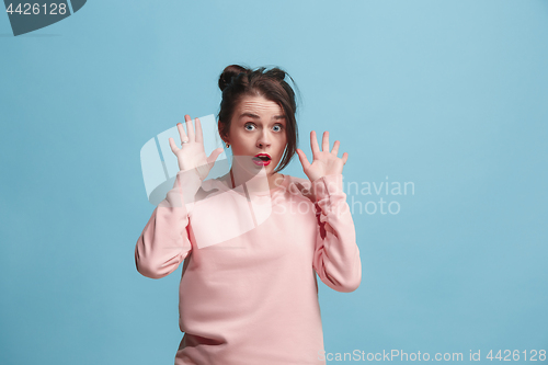 Image of Beautiful woman looking suprised isolated on blue