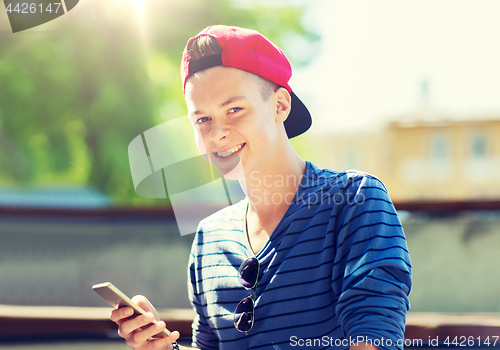 Image of happy teenage boy with smartphone outdoors