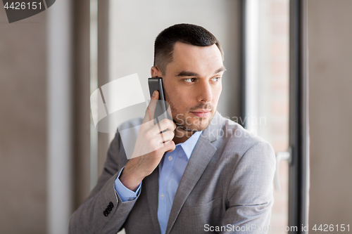 Image of businessman calling on smartphone at office