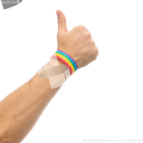 Image of hand with gay pride rainbow wristband shows thumb