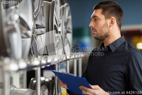 Image of auto business owner and wheel rims at car service