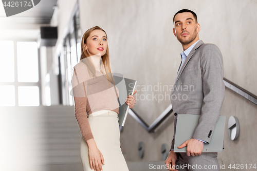 Image of businesswoman and businessman with folder