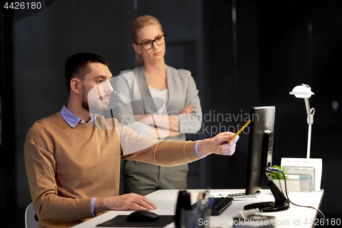 Image of business team with computer working late at office