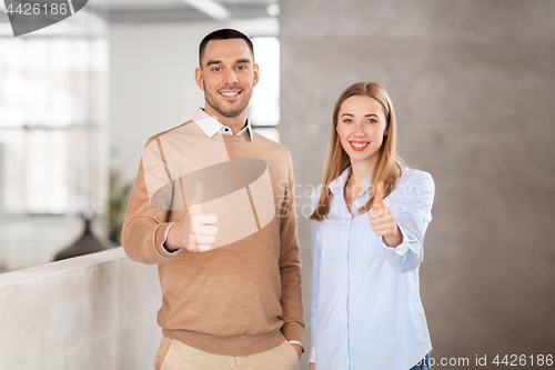 Image of businesswoman and businessman showing thumbs up