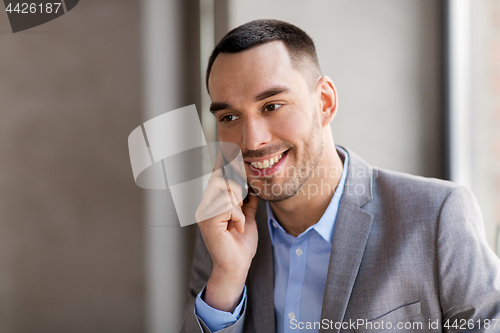 Image of businessman calling on smartphone at office