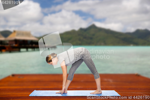 Image of woman making yoga intense stretch pose outdoors