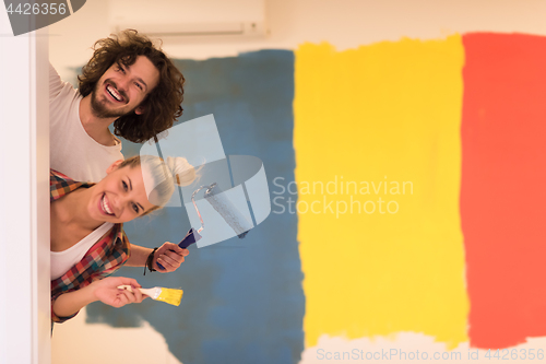 Image of portrait of a couple painting interior wall