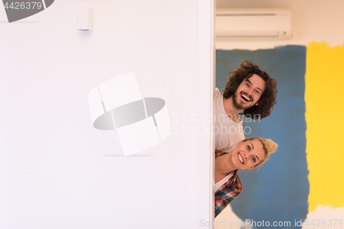 Image of portrait of a couple painting interior wall