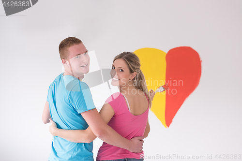 Image of couple are painting a heart on the wall