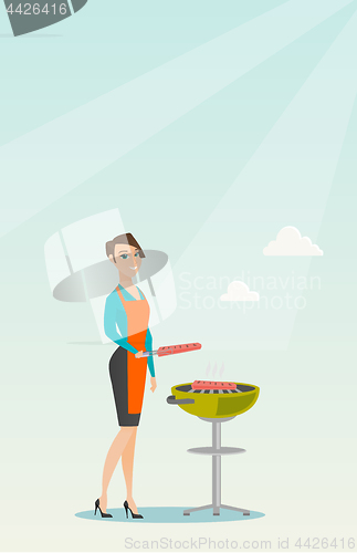 Image of Woman cooking steak on barbecue grill.