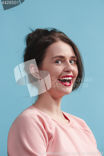 Image of The happy business woman standing and smiling against blue background.