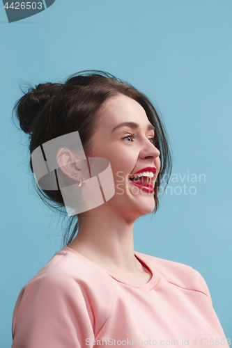 Image of The happy business woman standing and smiling against blue background.