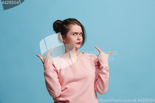 Image of Beautiful woman looking suprised and bewildered isolated on blue