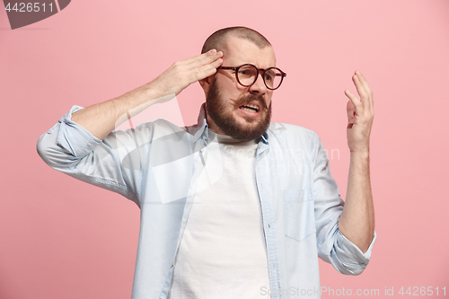 Image of Man having headache. Isolated over pink background.