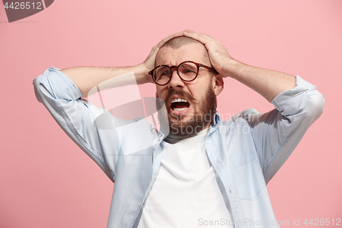 Image of Man having headache. Isolated over pink background.