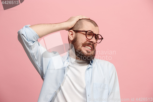 Image of Man having headache. Isolated over pink background.