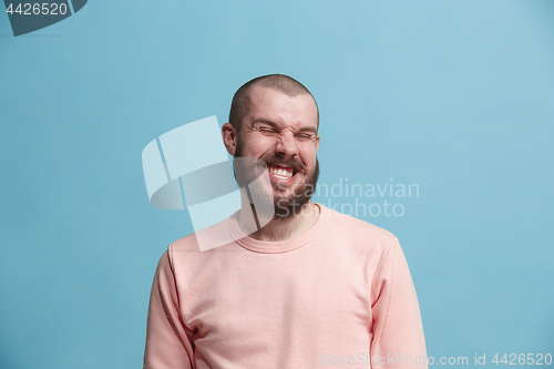 Image of The happy business man standing and smiling against blue background.