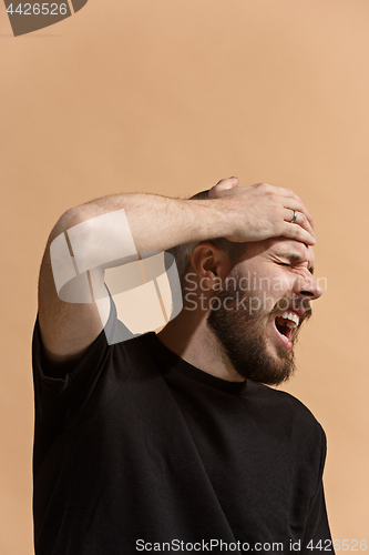 Image of Man having headache. Isolated over pastel background.