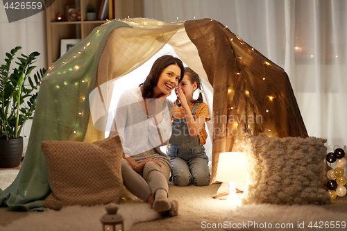 Image of happy family whispering in kids tent at home