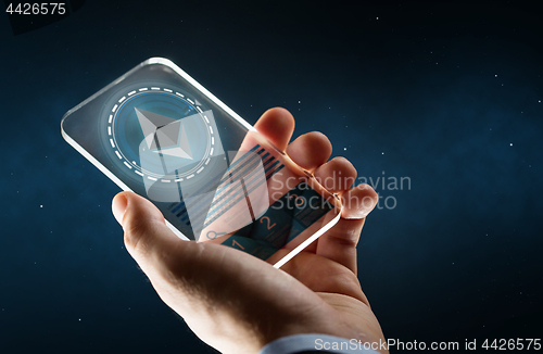 Image of male hand with ethereum on smartphone screen