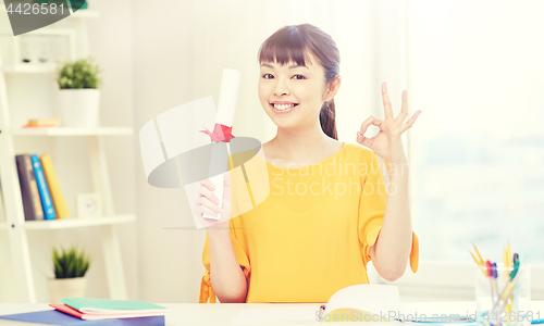 Image of happy asian woman student with diploma at home