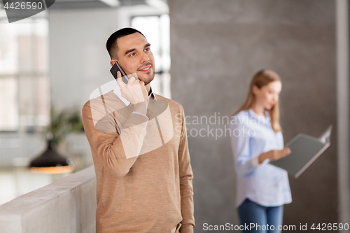 Image of businessman calling on smartphone at office