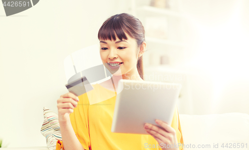 Image of happy asian woman with tablet pc and credit card