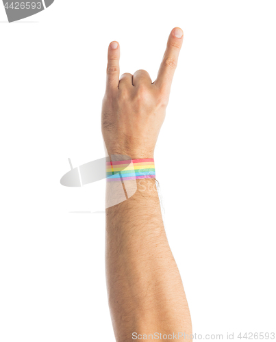 Image of hand with gay pride rainbow wristband shows rock
