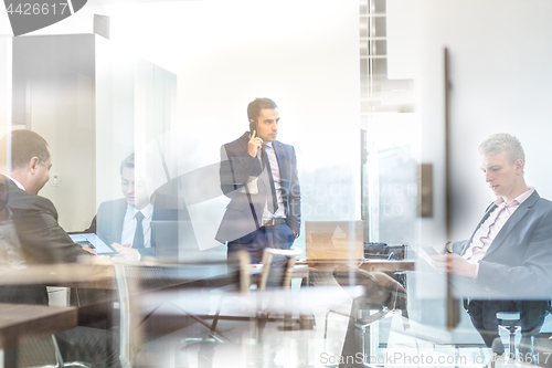 Image of Businessman talking on a mobile phone on corporate office.