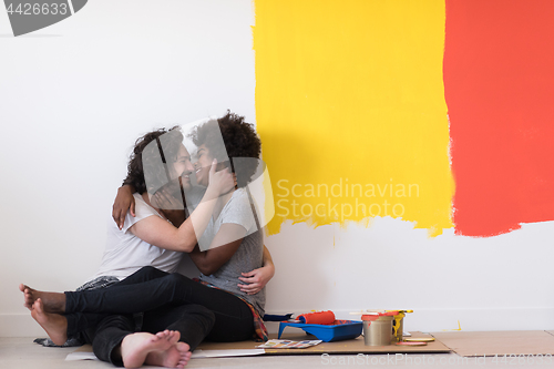 Image of young multiethnic couple relaxing after painting