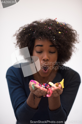 Image of African American woman blowing confetti in the air