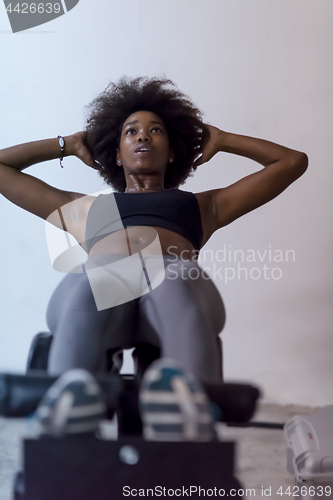 Image of black woman doing sit ups at the gym
