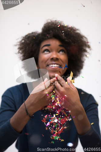 Image of African American woman blowing confetti in the air