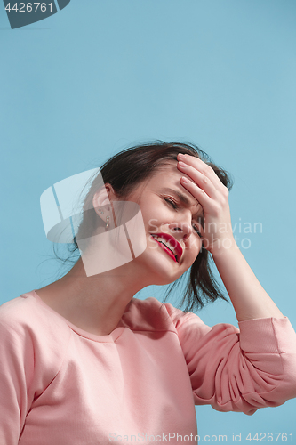 Image of Woman having headache. Isolated over blue background.