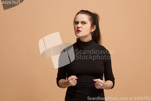 Image of Portrait of an angry woman looking at camera isolated on a pastel background