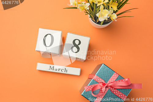 Image of The top view of orange desk with gift, flowers and notebook