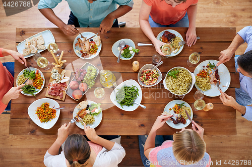 Image of group of people eating at table with food