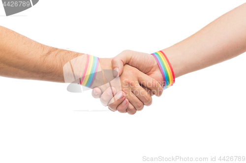 Image of hands with gay pride wristbands make handshake