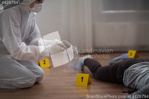 Image of criminalist collecting crime scene evidence