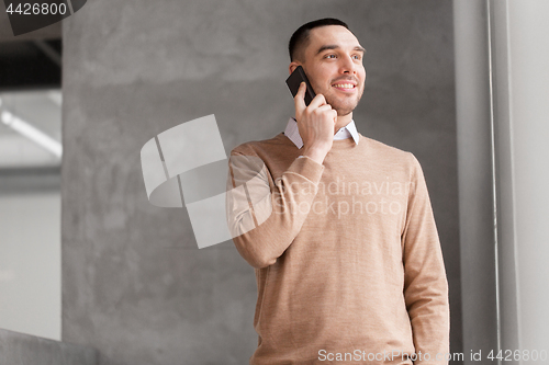 Image of businessman calling on smartphone at office