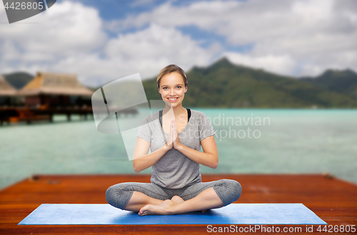 Image of woman making yoga in and meditating lotus pose