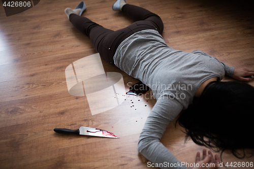 Image of dead woman body lying on floor at crime scene